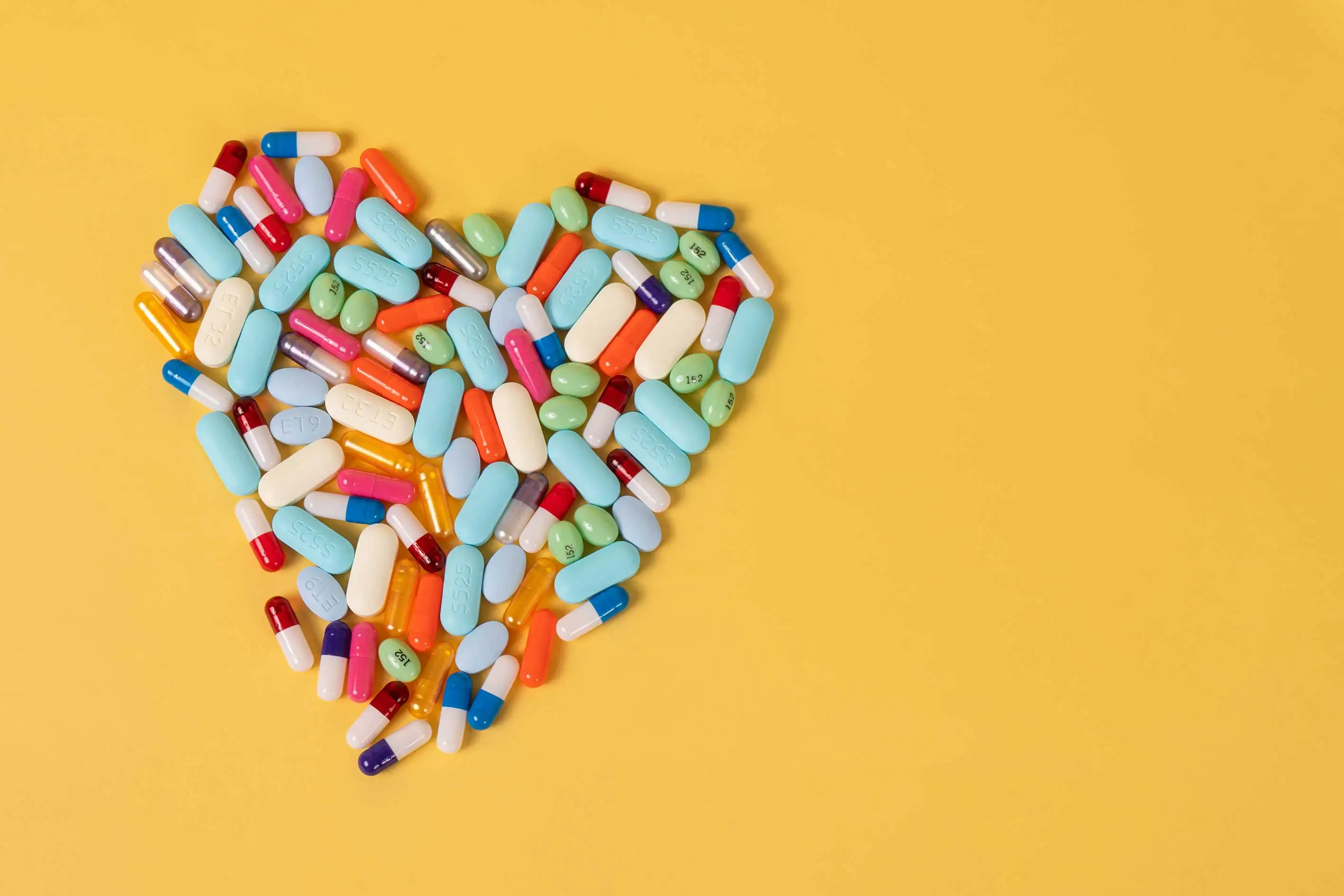 Herz aus Tabletten auf einem orangenem Hintergrund